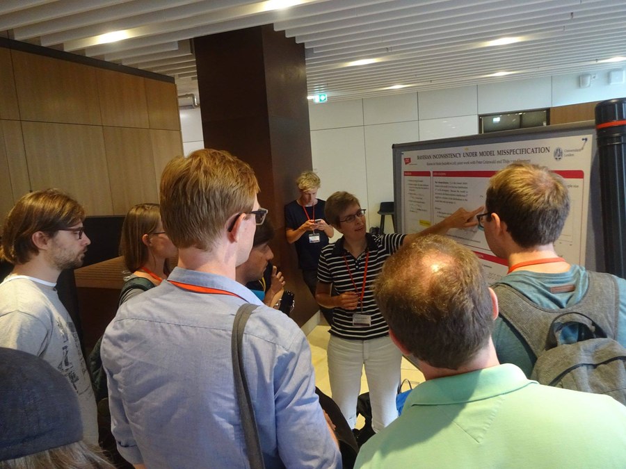 Rianne de Heide discussing a research poster with conference participants