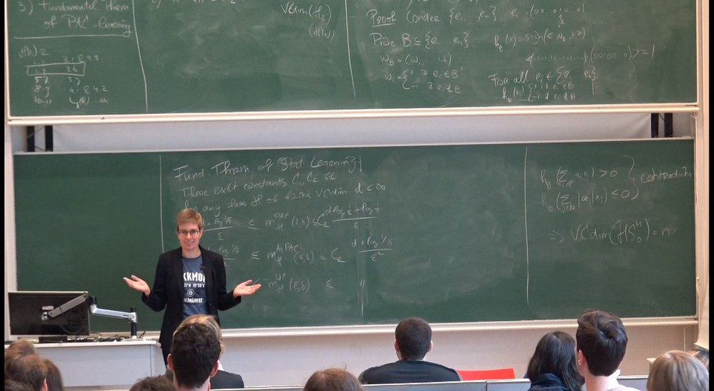 Rianne de Heide teaching a Machine Learning Theory class at a blackboard